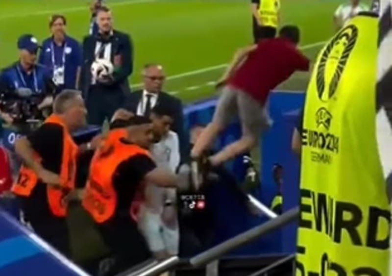 Ronaldo được bảo vệ trước một kẻ xâm lược sân trái phép.